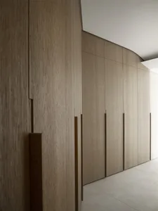 A modern minimalist interior featuring wooden cabinets, emphasizing sleek design and clean lines.