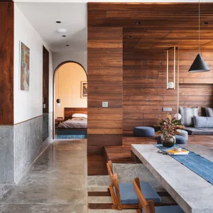 A modern residential living space featuring concrete and wood materials and a minimalist design.