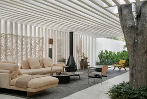 A minimalist living room featuring concrete and wooden elements with green plants.