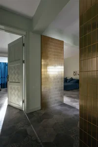 A modern living space featuring metallic tiled walls and hexagonal floor tiles with geometric patterns.