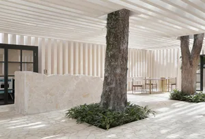 Modern minimalistic living room with concrete floor and natural stone accents