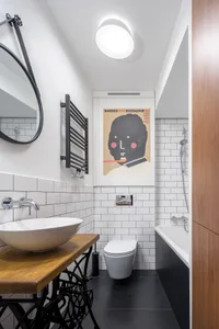 Modern bathroom with white subway tiles, black floor tiles, and minimalist design.
