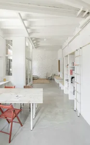 Modern minimalist office space with concrete walls and white furniture