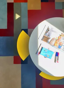 A colorful interior scene featuring a round table with books and markers.