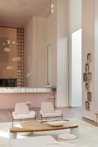 Modern living room with minimalist furniture and warm lighting, featuring soft sofas and a minimalistic table.