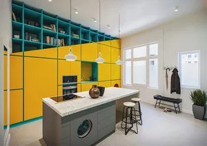 A minimalist kitchen featuring bright yellow lacquered cabinets, a green metal structural element, and a marble kitchen islan