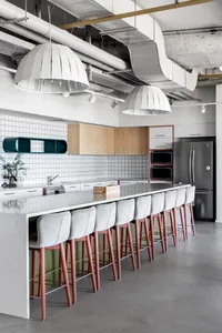 Industrial-style modern kitchen with concrete countertops and wood cabinetry.