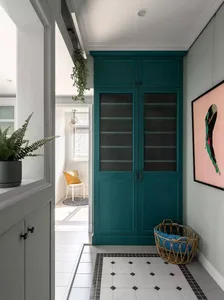 Teal wooden cabinet in an entrance hallway.