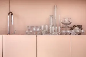 A collection of glassware and vases displayed in a minimalist kitchen setting.