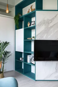 Modern living room featuring metal shelves and a marble accent wall.