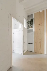 Modern, minimalist apartment interior with concrete flooring and white walls.