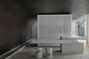 A minimalist concrete interior design featuring a grid wall and contemporary furniture.