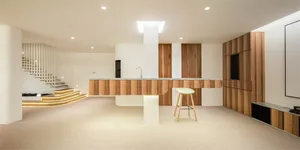 A modern kitchen featuring wooden cabinets and a marble countertop.