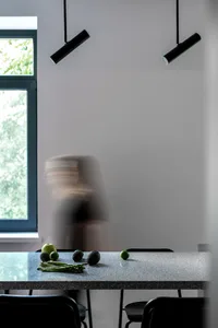 A minimalist kitchen with a granite countertop featuring avocados, lemons, and asparagus.