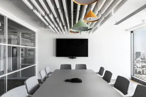一間現代會議室，配有混凝土家具、極簡設計，以及可俯瞰城市景觀的大窗。