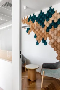A modern office lounge with textured acoustic paneling on the wall.