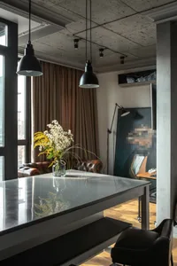 Modern industrial living room with concrete walls, leather furniture, and concrete floor.