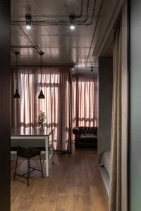 A residential interior featuring industrial-style decor with curtains and flooring.