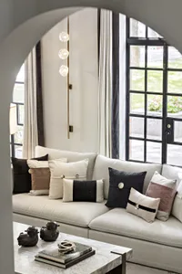 Modern residential living room with a white couch, textured marble coffee table, and glass lighting.