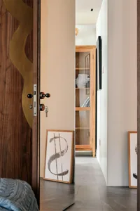 Modern hallway interior with wooden flooring, doors, and shelves.