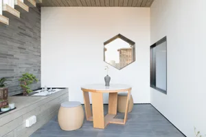 A modern interior design featuring a table with marble tabletop and wooden stools.