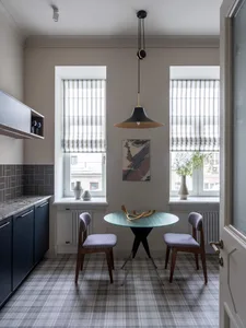 A modern kitchen with a glass table and two upholstered chairs.