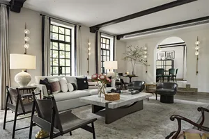 現代客廳擺放大理石咖啡桌、白沙發與黑色椅子。