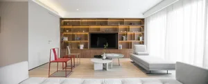 A modern minimalist living room featuring wooden shelves and fabric seating.