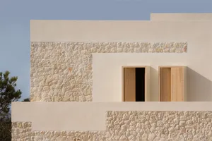 Modern, minimalist building exterior featuring painted stone and concrete