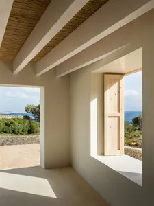 An interior space featuring minimalist design with concrete and natural wood materials.