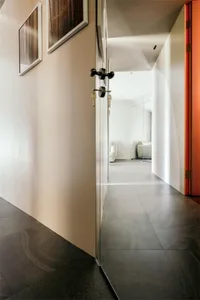 Modern corridor with white walls, minimalist decor, and dark flooring.
