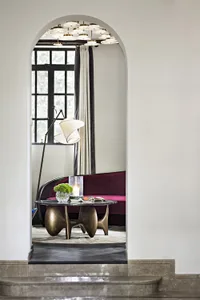 Modern living room featuring a marble and wooden sofa with a chandelier and candle.