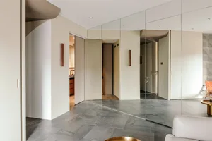 Modern living room featuring glass panel walls, minimalistic decor, and a sleek, contemporary design.