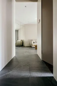A modern living room featuring sleek, minimalist design with concrete tiles flooring.