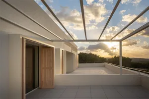 A modern terrace featuring concrete floors and walls with a view of lush greenery at sunset.