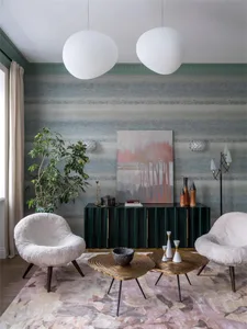 Modern living room with metallic tables, green-wood cabinet, and suede armchairs.
