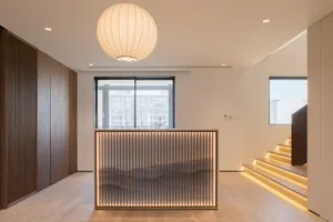 A modern residential entryway featuring a wooden barrier and warm lighting.