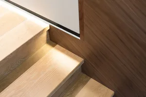 Modern, wooden staircase with lighting detail.