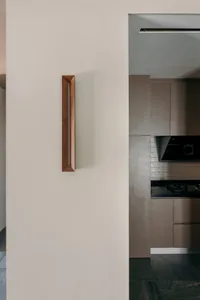 A modern kitchen interior featuring a wooden handle on a door or cabinet.