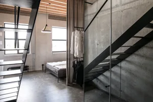 Modern industrial-style bedroom featuring concrete walls and a minimalist design.
