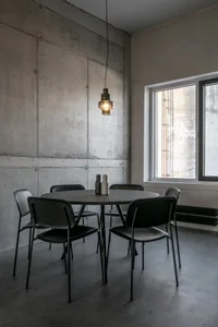 An industrial-designed dining room featuring concrete walls and flooring.