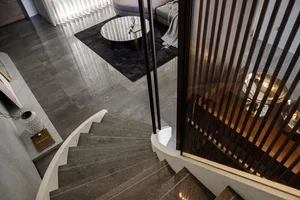 A minimalist interior staircase with wooden railings and marble steps.