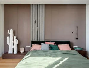 Modern bedroom with a bed, pillows, a cactus sculpture, and wood flooring.