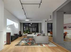 A modern living room with wood laminate flooring, a gray sectional sofa, and a colorful rug in front of a projector screen sh