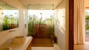 Modern minimalist bathroom featuring glass walls and concrete flooring.