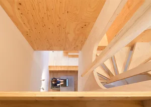 Minimalist interior space featuring wood elements and a spiral staircase