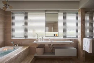 Modern bathroom with concrete walls, a white floating sink, and blinds on the window.