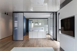 A modern bedroom suite featuring white-painted walls, a white wooden floor, and a minimalist design.