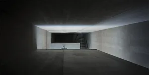 A photo of a modern, minimalist concrete interior space with a staircase.