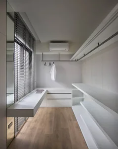 Modern white closet with minimalist design and wooden flooring.